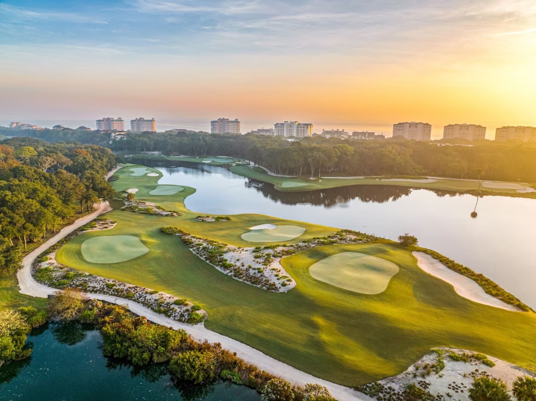 Sandy par-3 greens ringing Red Maple Lake, the resort by the ocean beyond