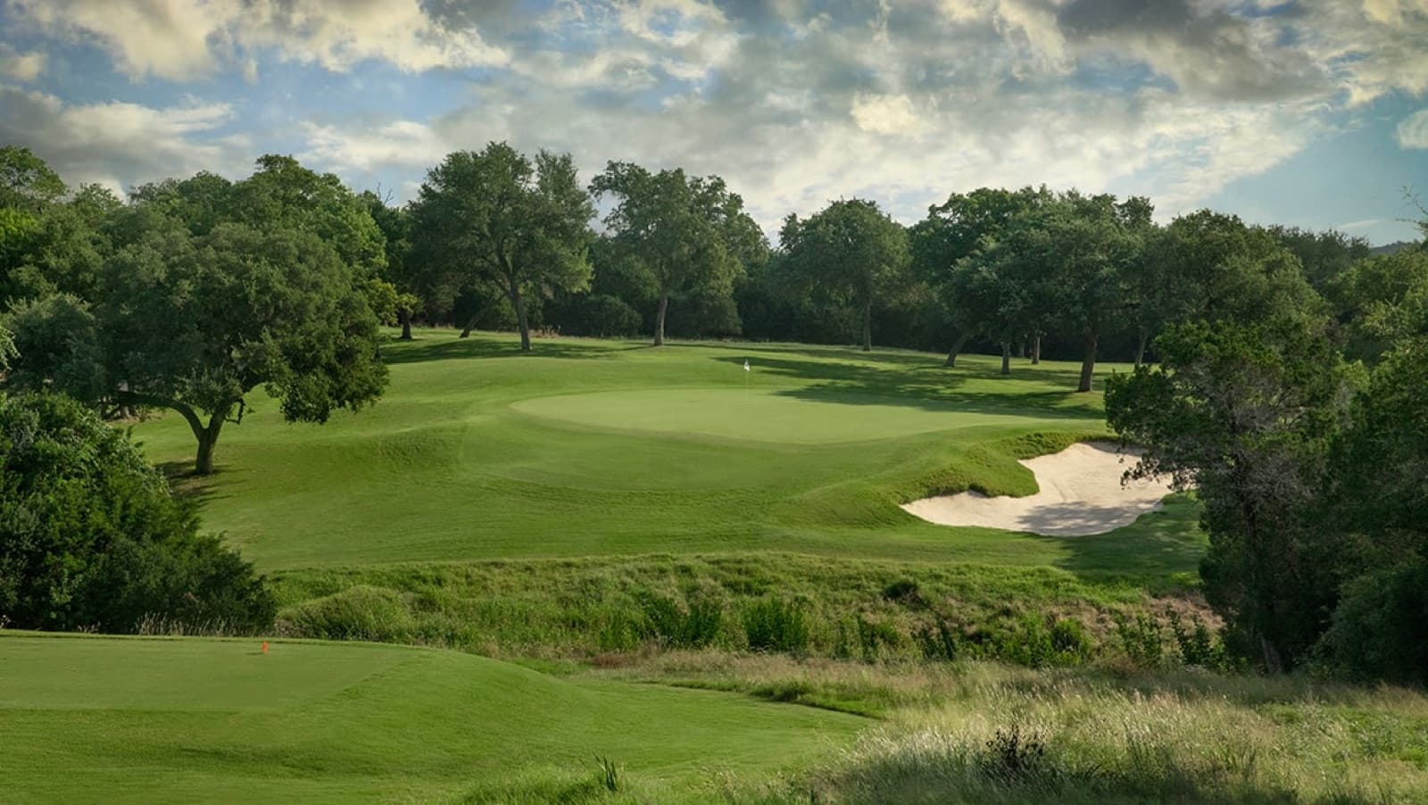 a natural green among the live oaks on the Coore & Crenshaw