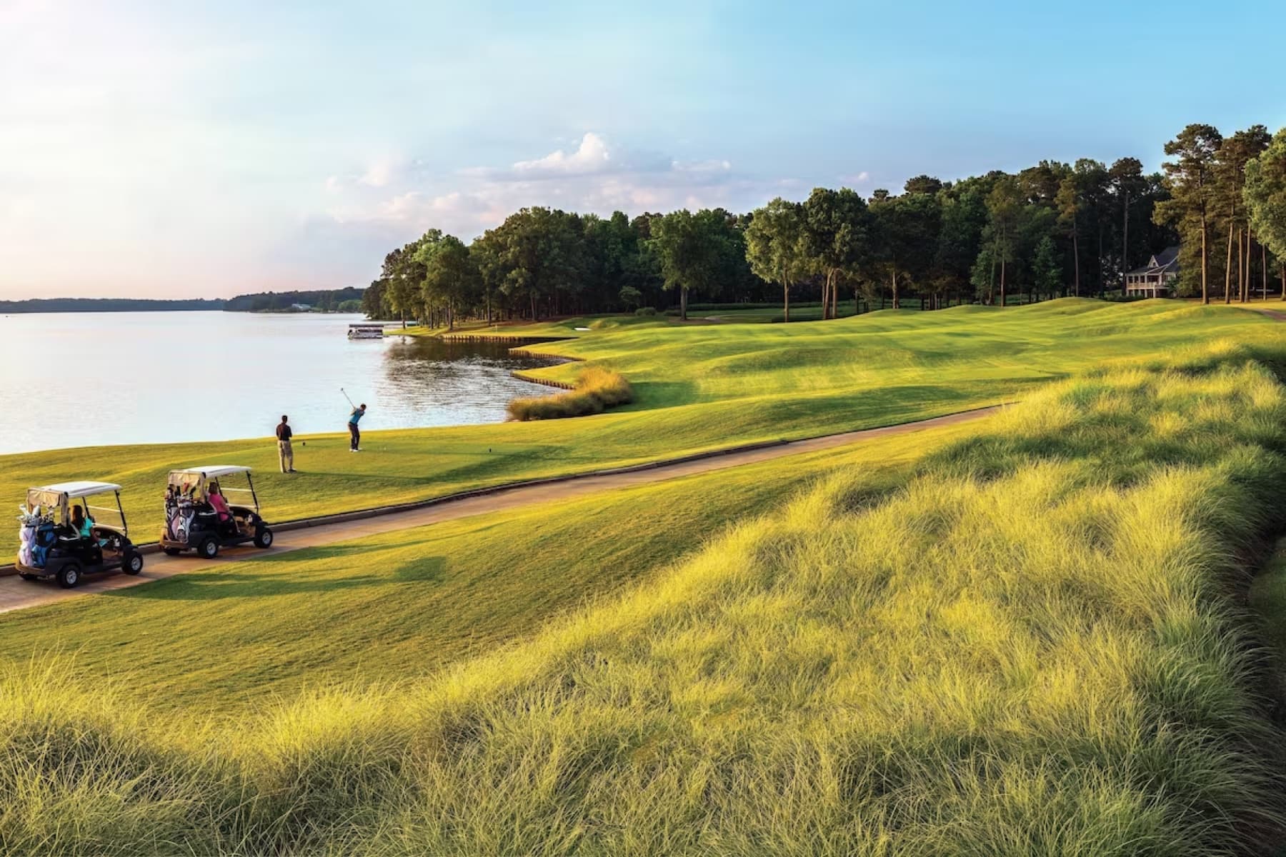 Native grasses framing a lakeside tee on The Landing.